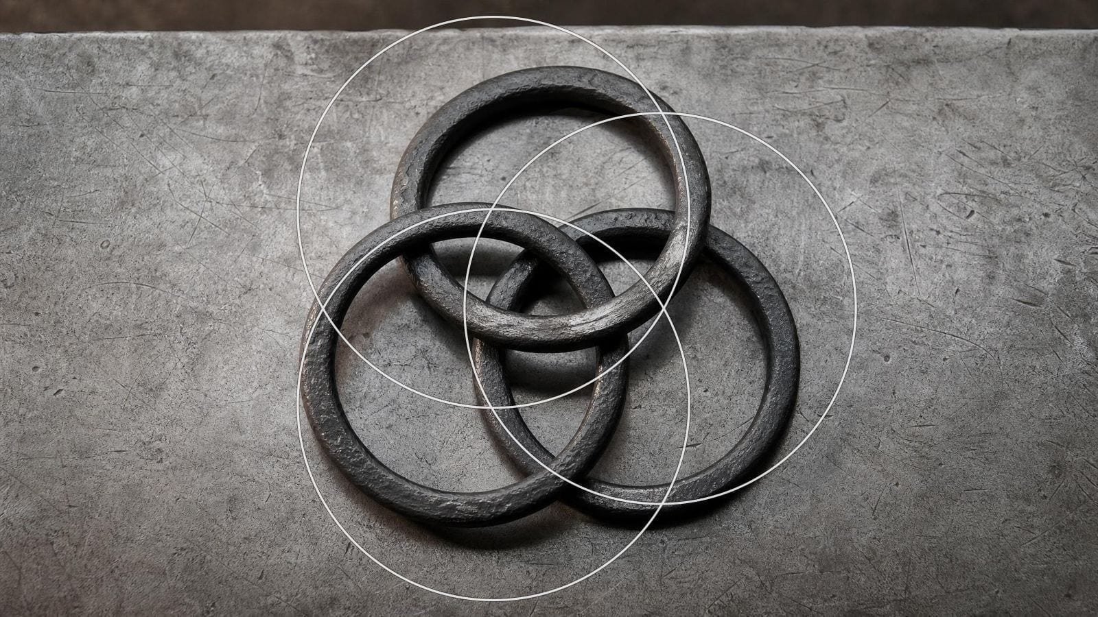 Borromean rings overlay on three equal forged iron rings interlinked on an anvil