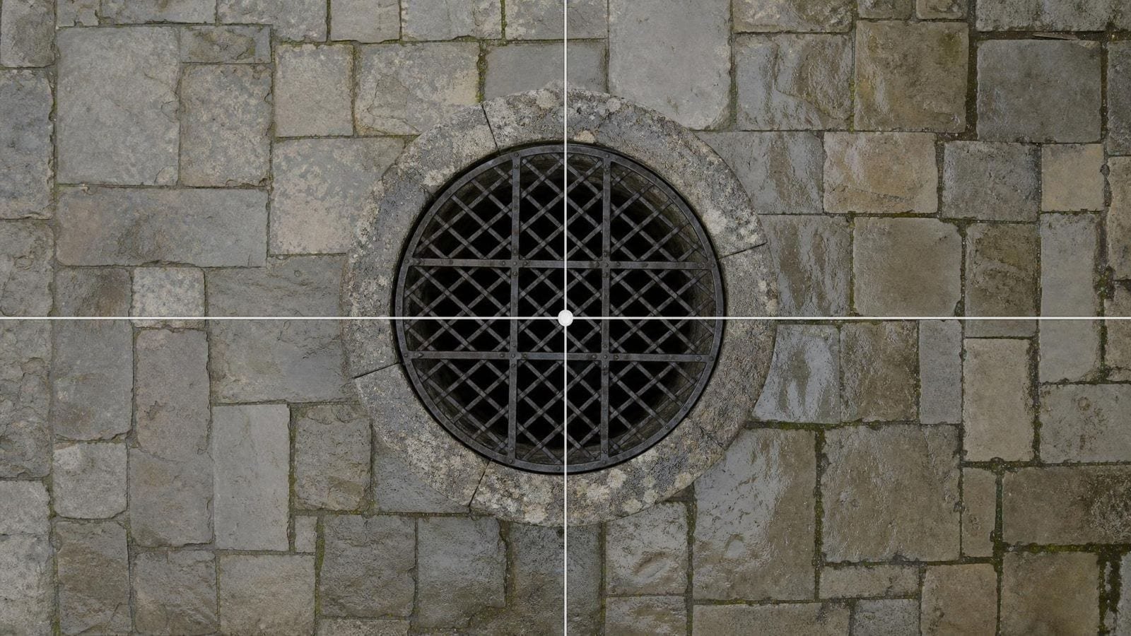 Center cross overlay on a round well head set in the middle of a flagged courtyard