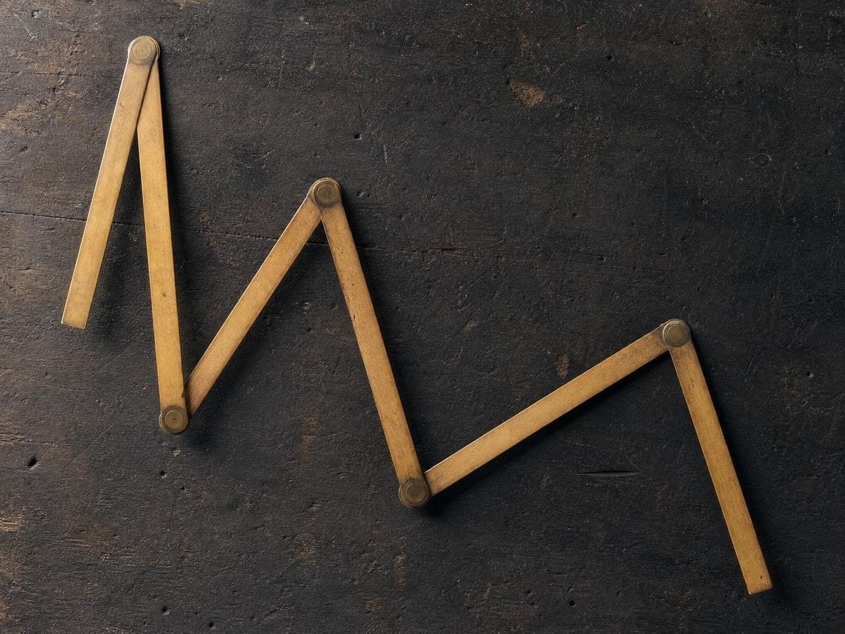 A brass-jointed boxwood folding rule opened into a series of irregular angles