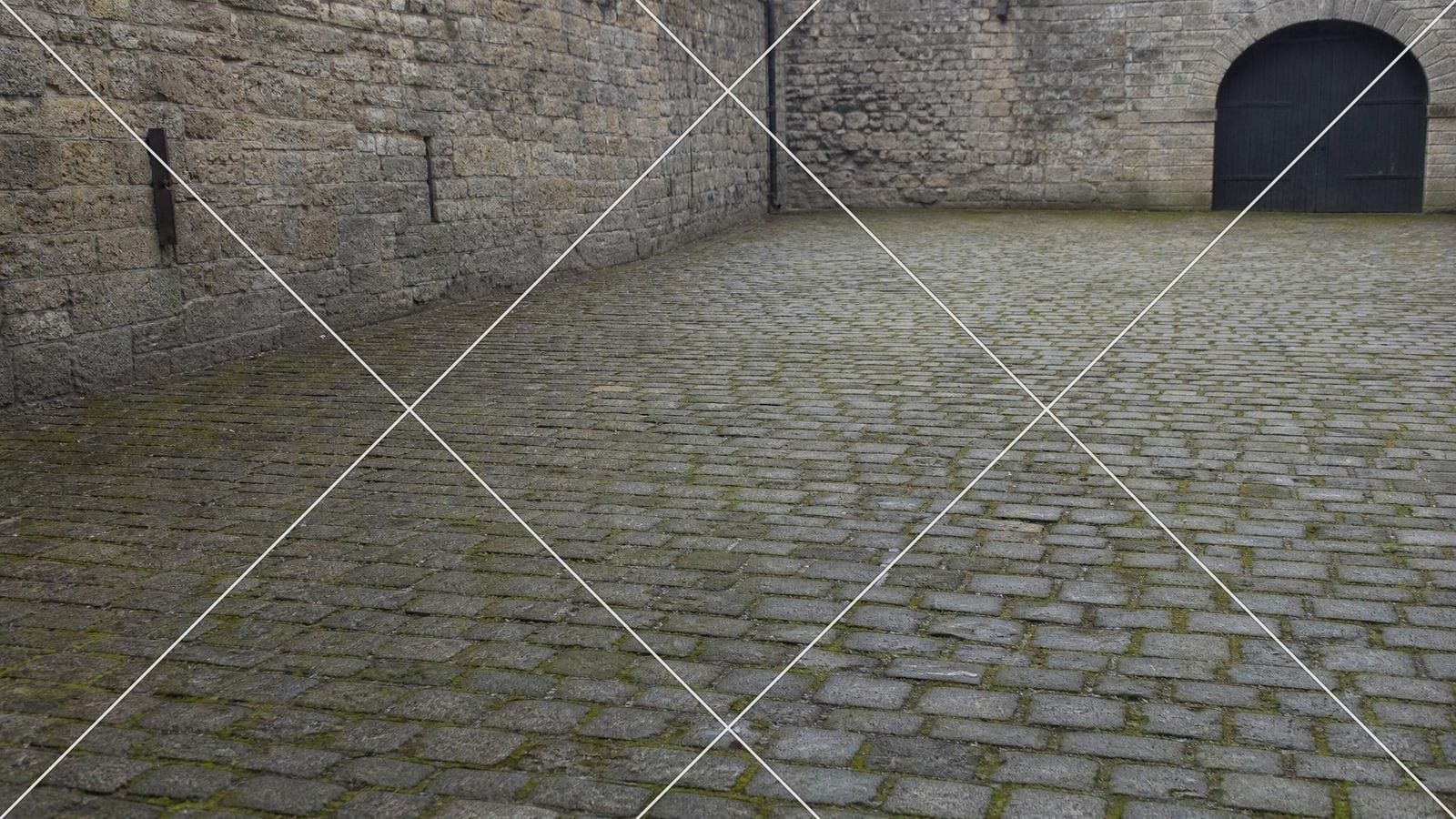 Diagonal method overlay on a damp cobbled coaching yard with a gate off to one side