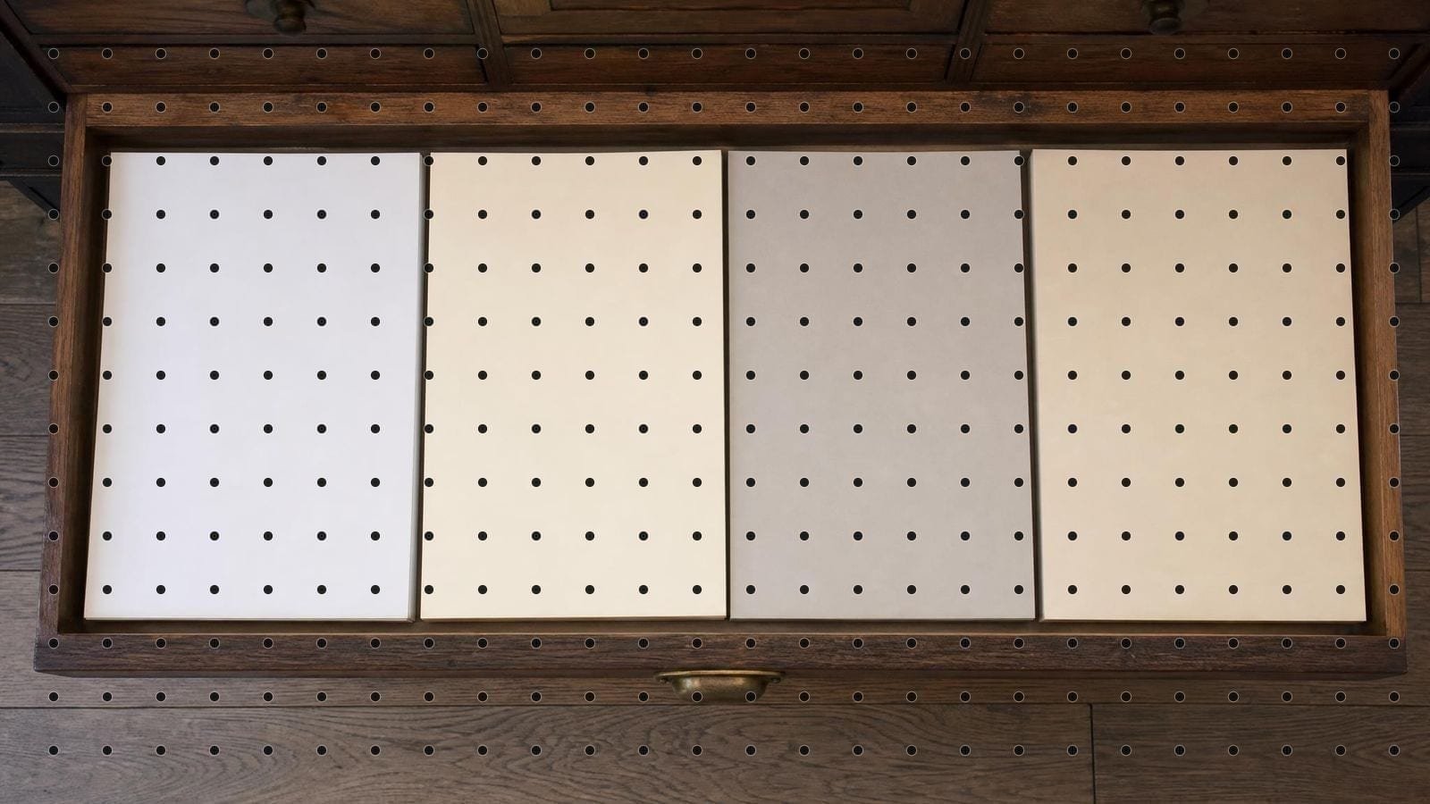 Graph paper overlay on a plan chest drawer of blank papers in four different stocks