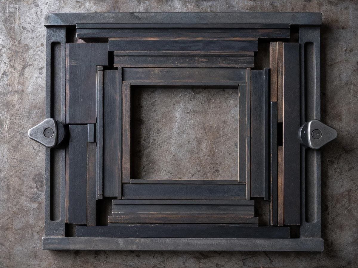 Wooden letterpress furniture and quoins locked around an empty rectangular space