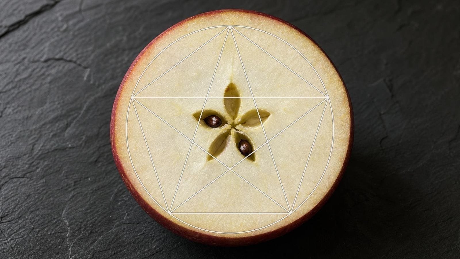 Pentagram overlay on an apple cut across the core showing five seed chambers