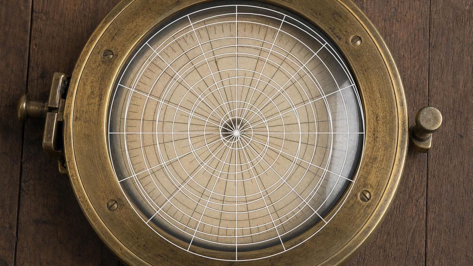 Polar grid overlay on a brass ship's compass card divided radially under domed glass