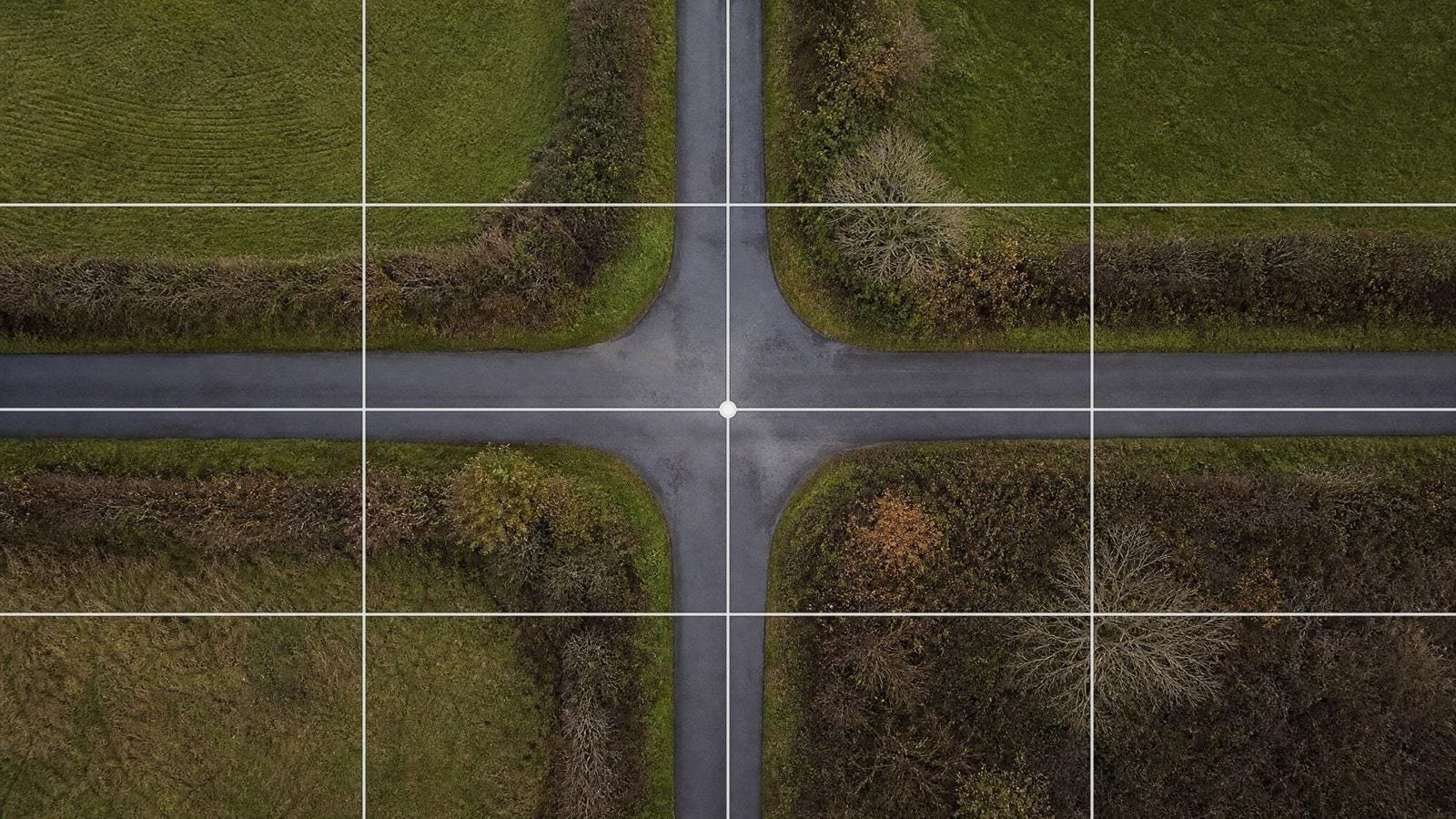Quadrant grid overlay on a rural crossroads seen from above, lanes meeting at the centre