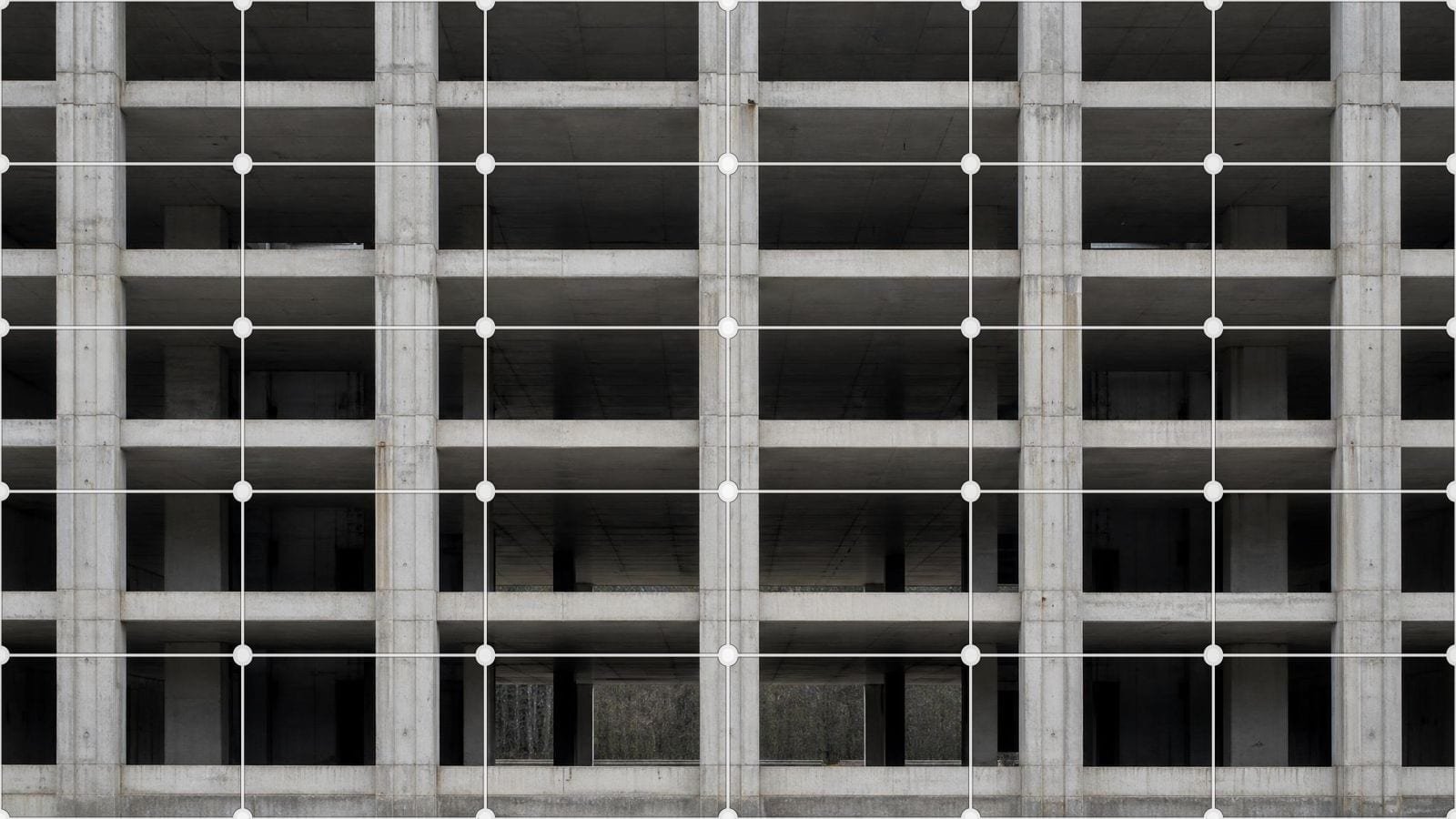 Structural grid overlay on a bare concrete frame of even column bays and floor slabs