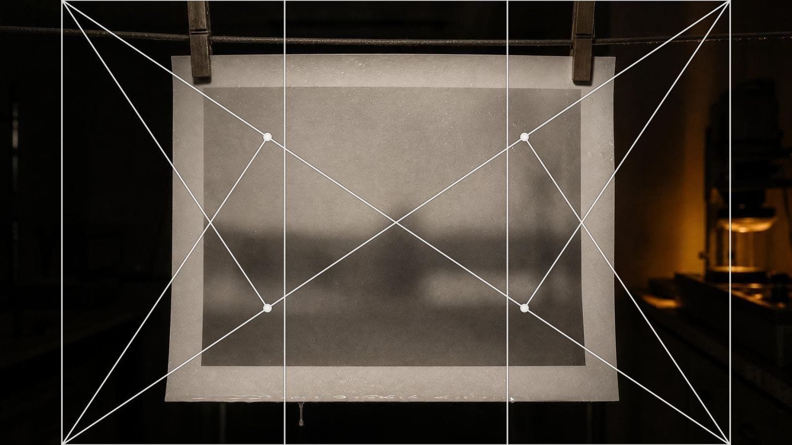 3:2 rectangle overlay on a wet monochrome print hanging in a darkroom on two pegs