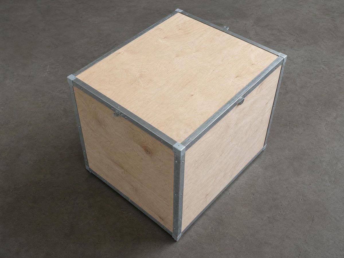 A battened plywood tea chest seen from above one corner, all three faces at different angles